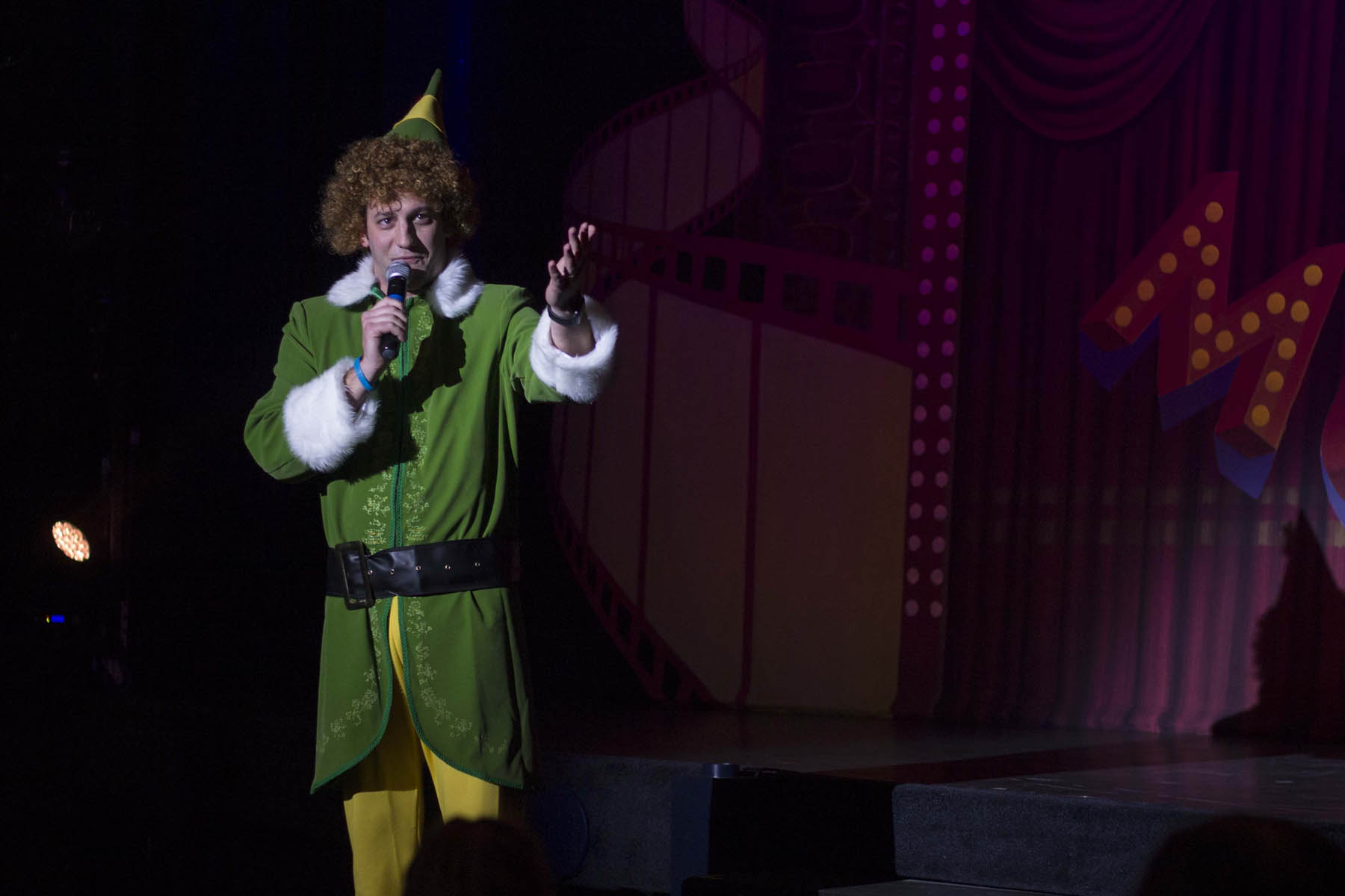 Man in elf costume singing.