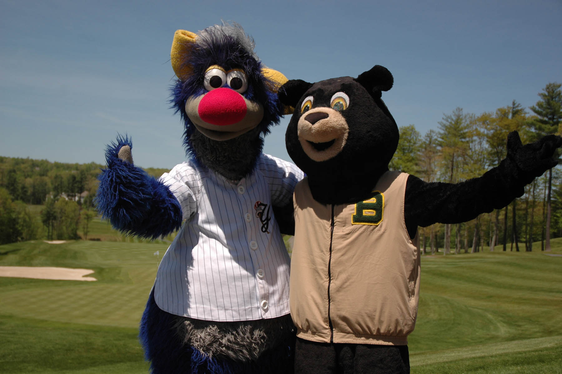Two mascots, Champ and Boomer, posing on golf course.