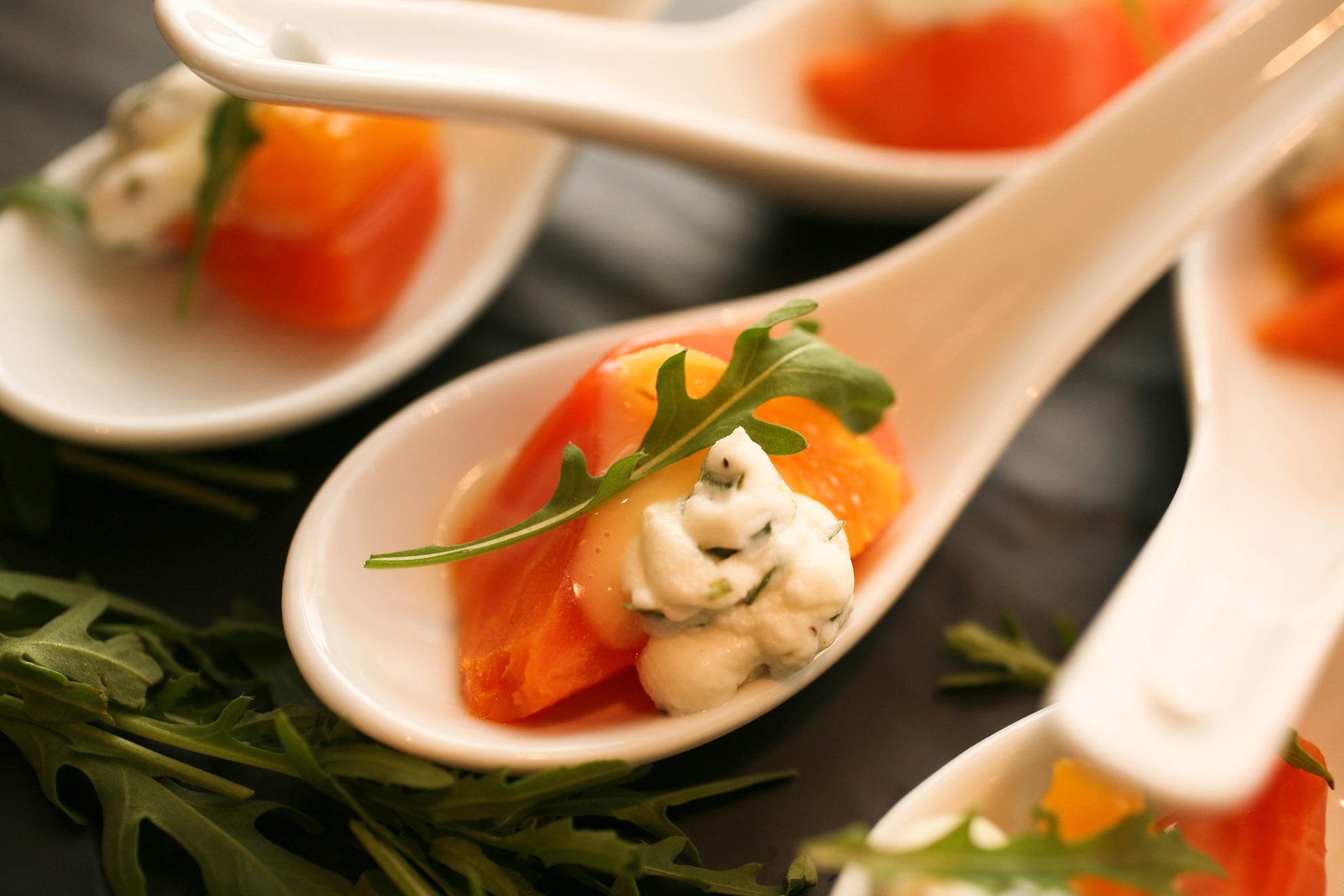 Close up of spoon with salmon and sauce.