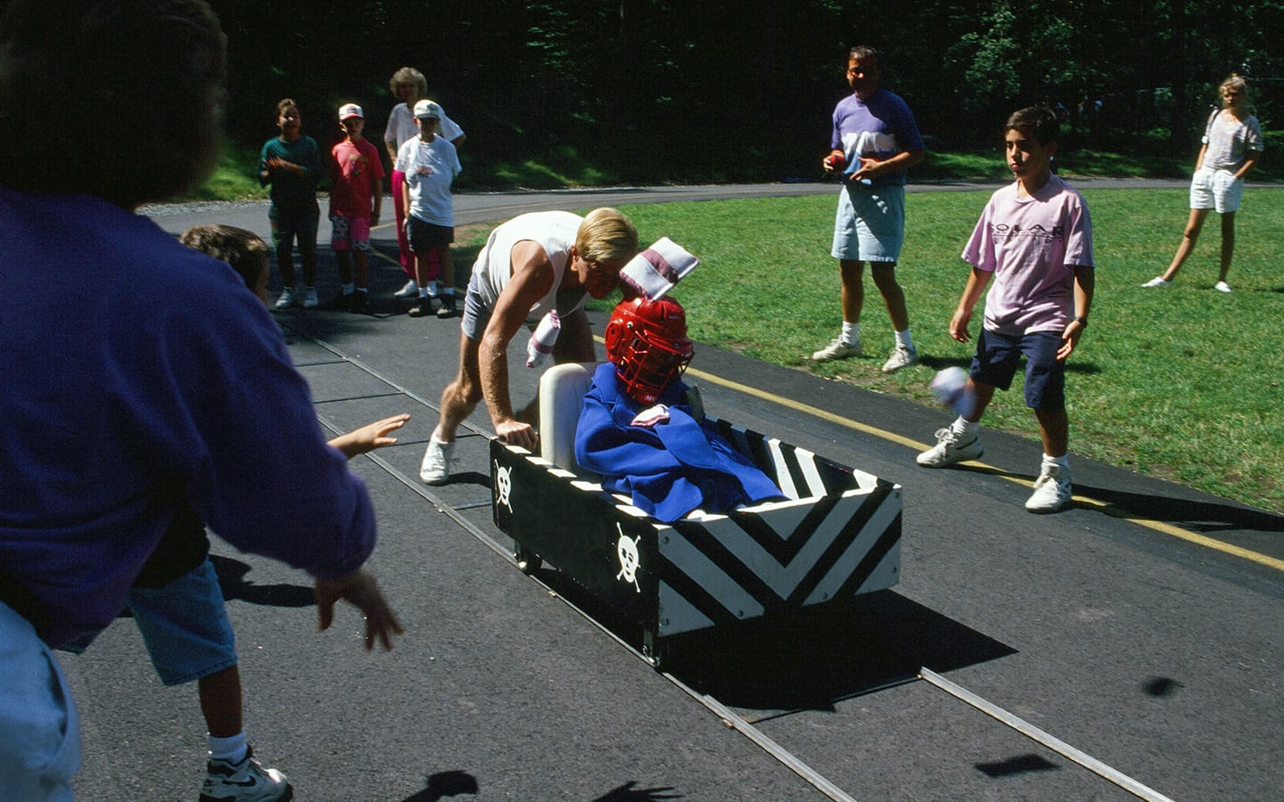 Olympic game. Person in a cart getting pushed by a team member.