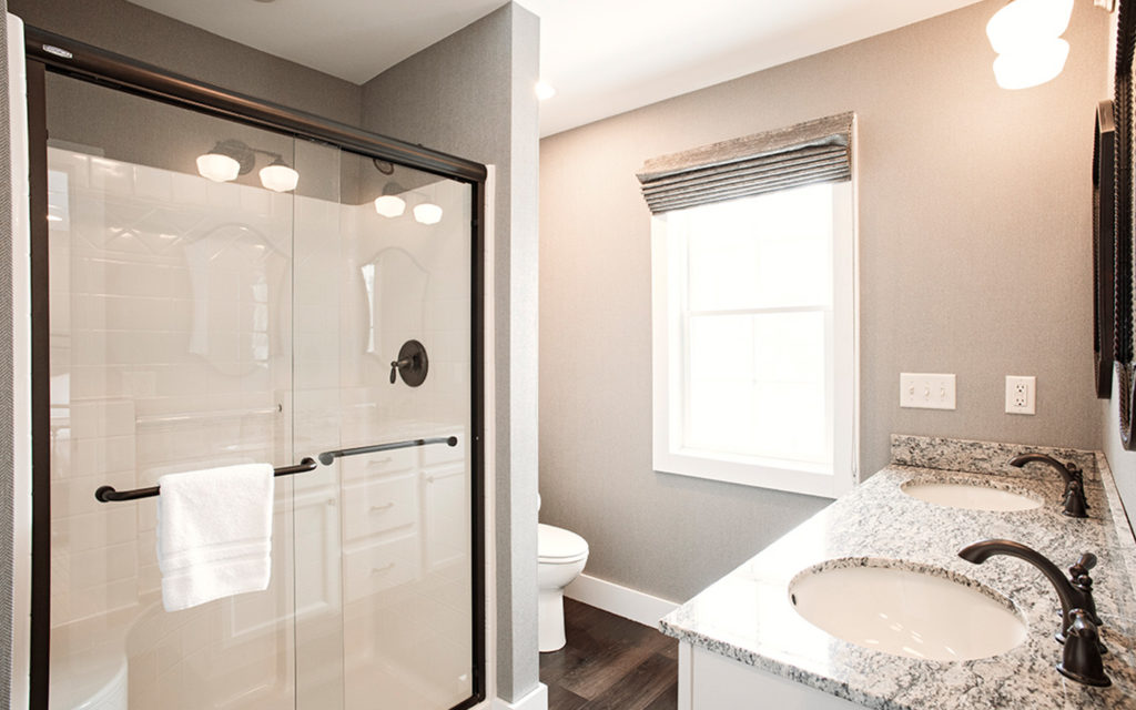 Tallwoods bathroom with shower and twin vanity sinks..