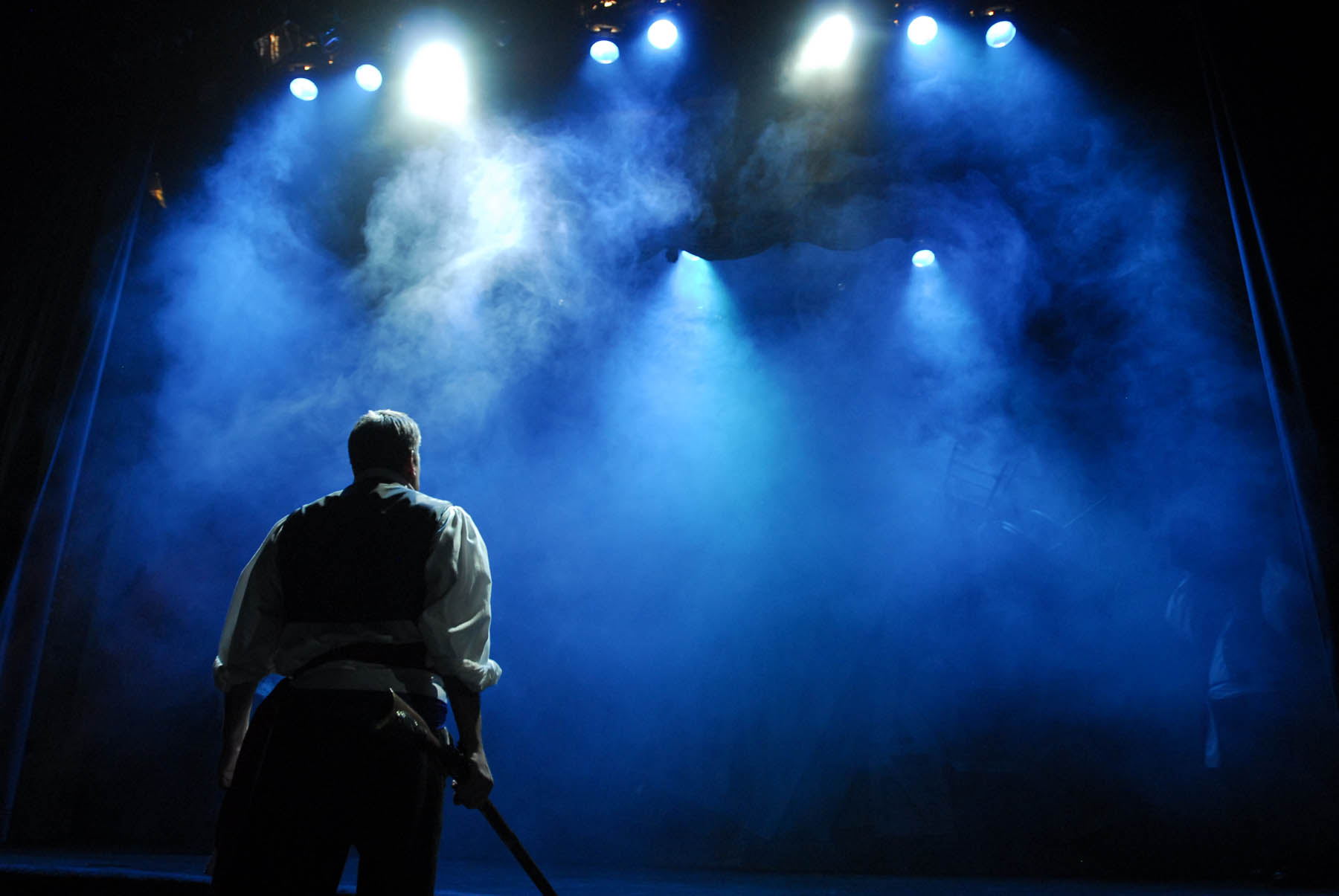 Man on stage with blue smoke.