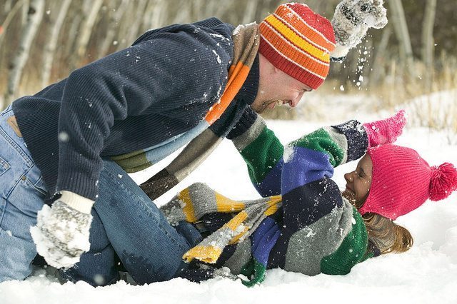 Woman and man playing in the snow.