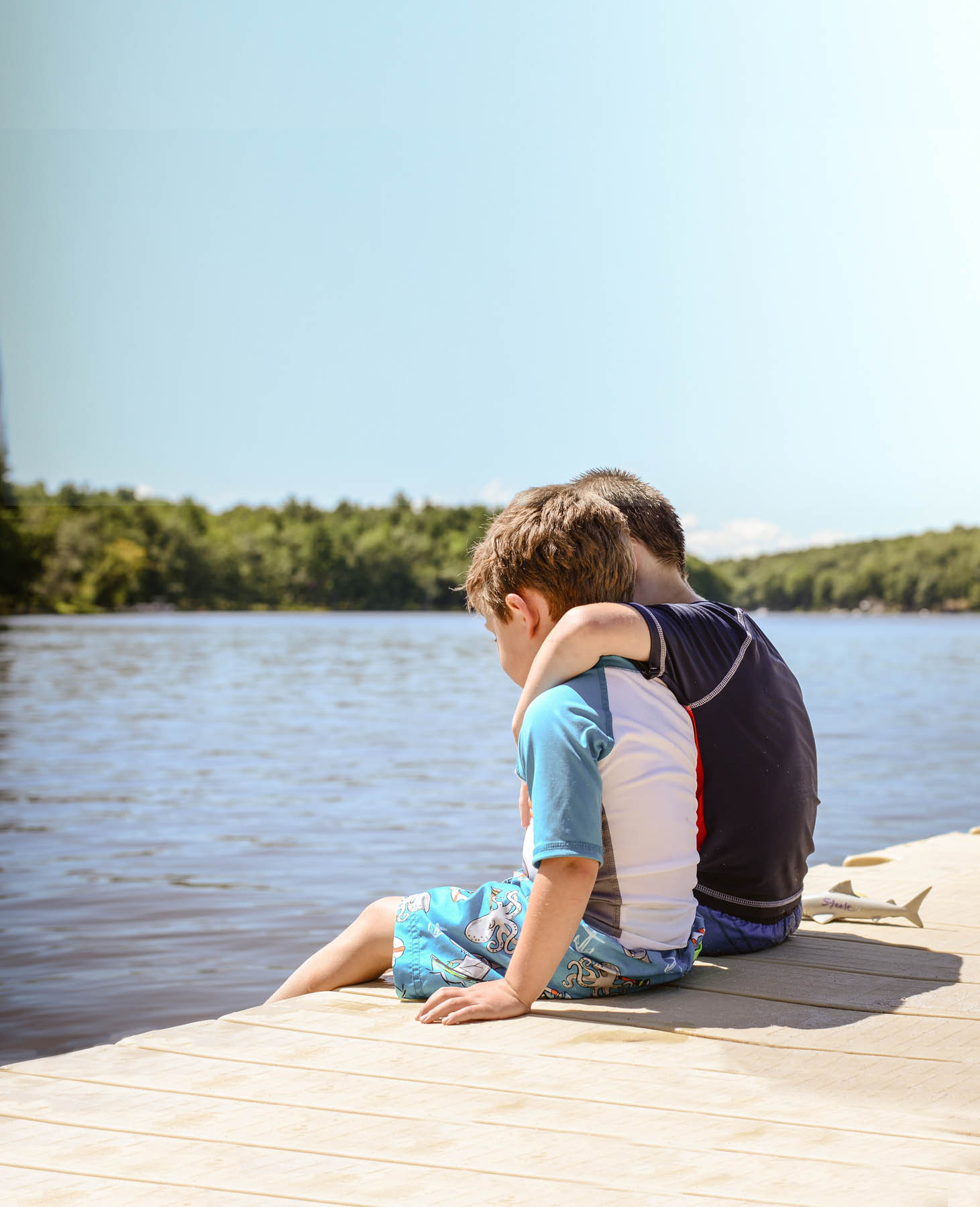 Two boys sitting on the dock.