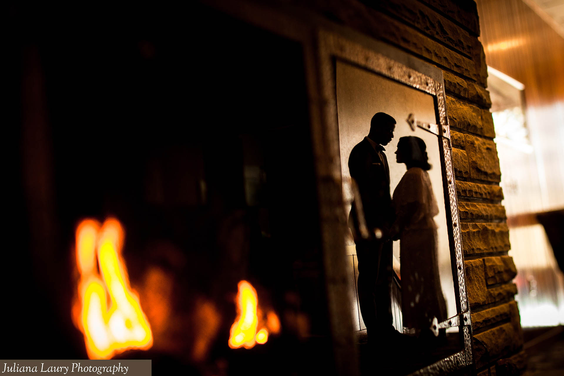 Bride and Groom reflected in fireplace glass.