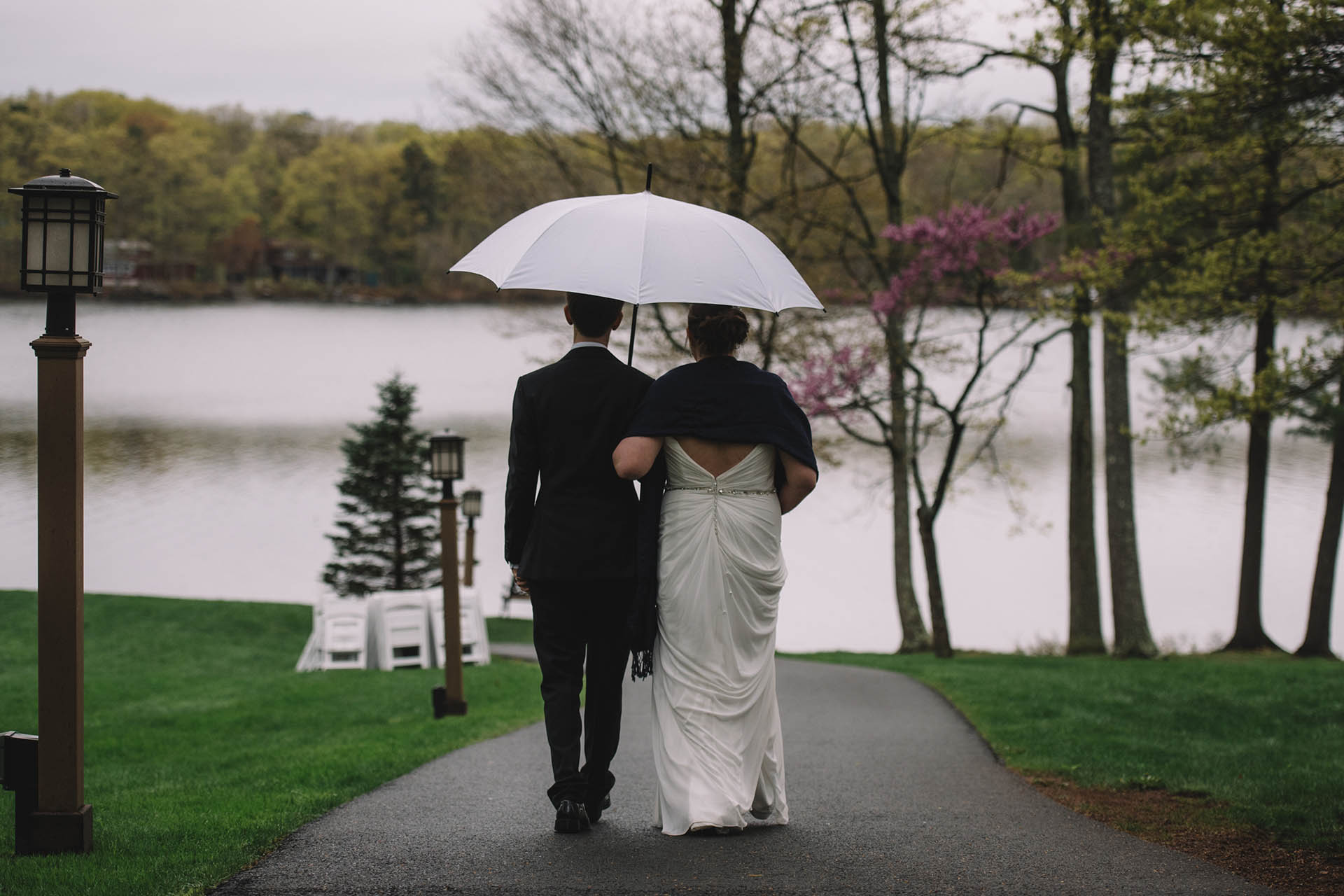 LGBT wedding couple walking outdoors in the rain.