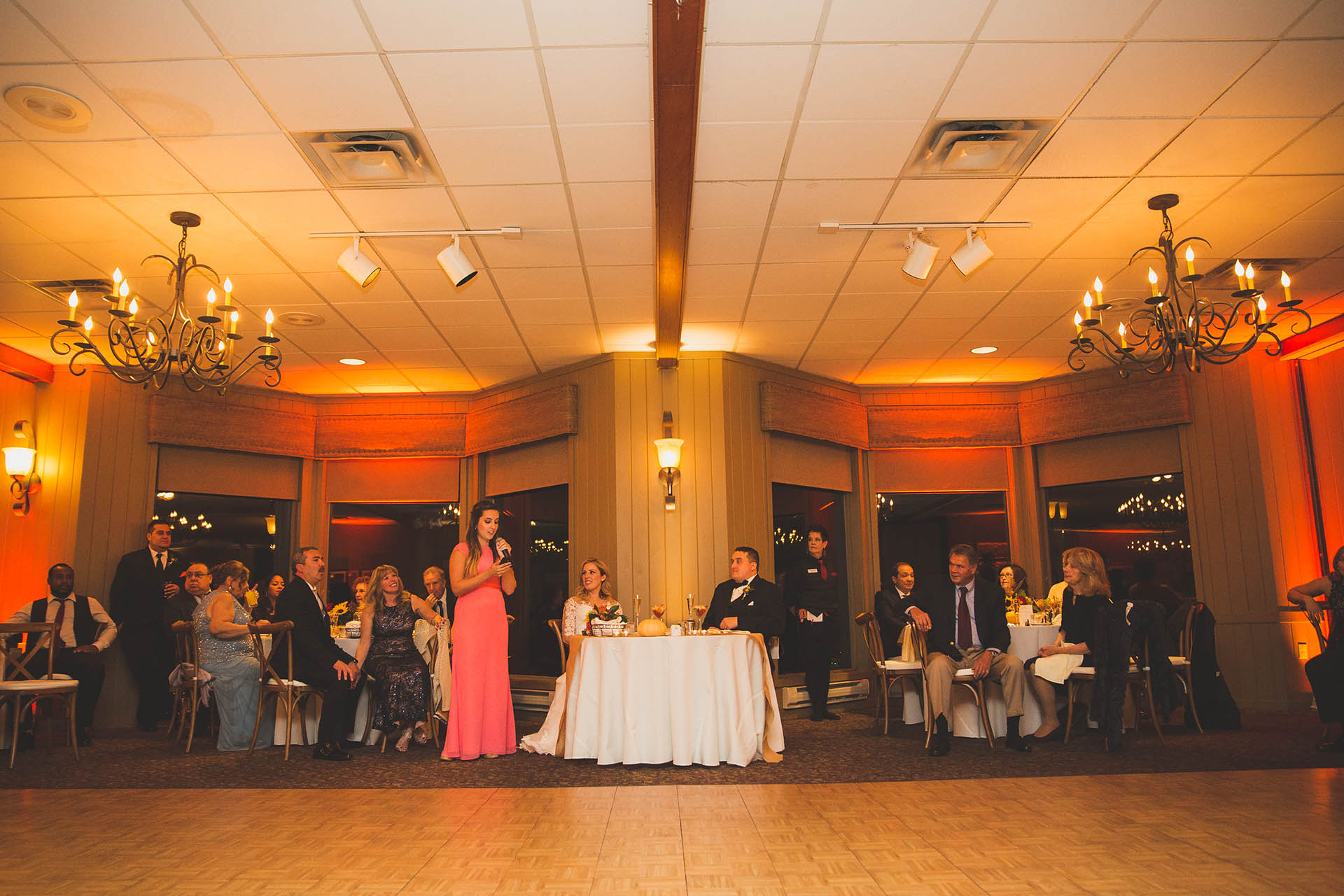 Bridesmaid delivering speech during wedding reception.