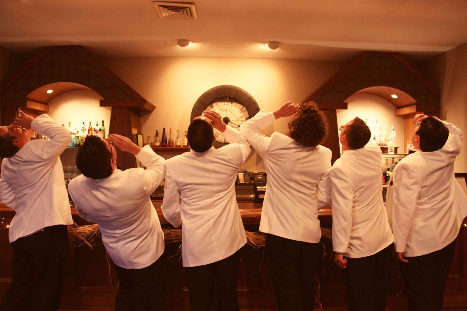 Groom and groomsmen taking a shot of liquor at the bar.