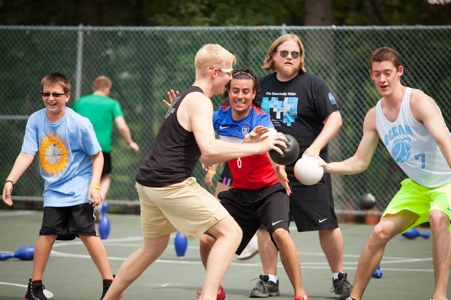 Young men playing game with bowling pins and soft balls.