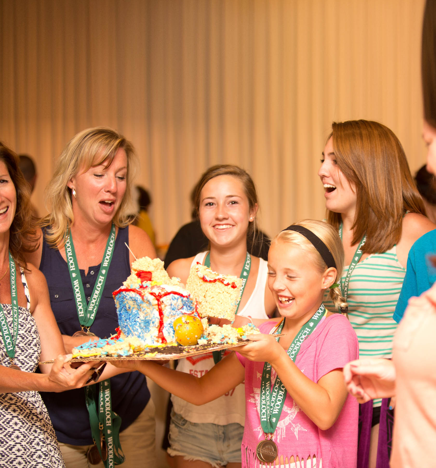 Women and young girl posing with a homemade cake.