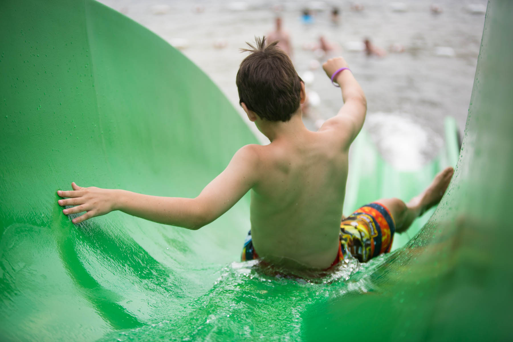 Young boy on a green waterslide