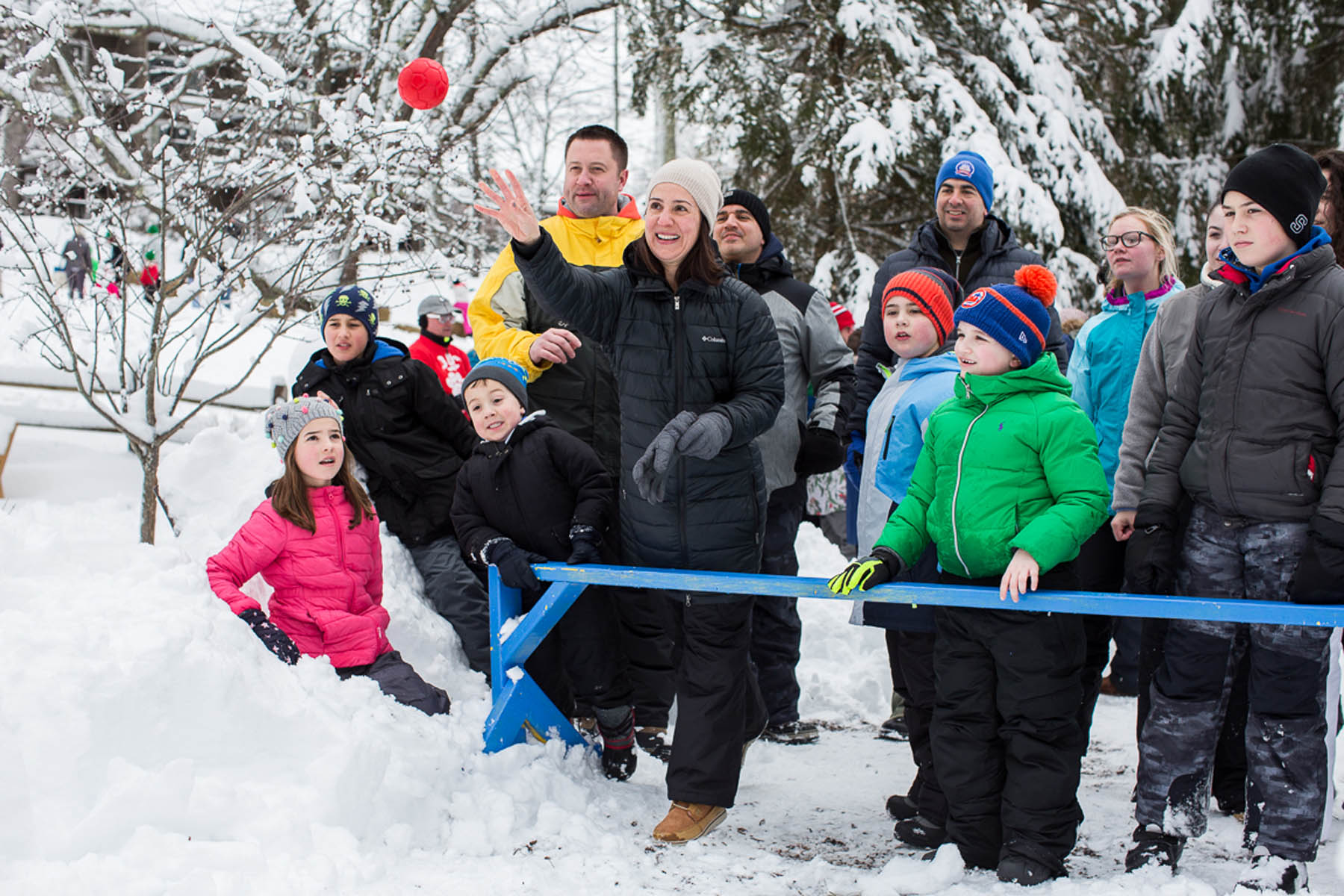 Woman throwing a snowball in front of a crowd.