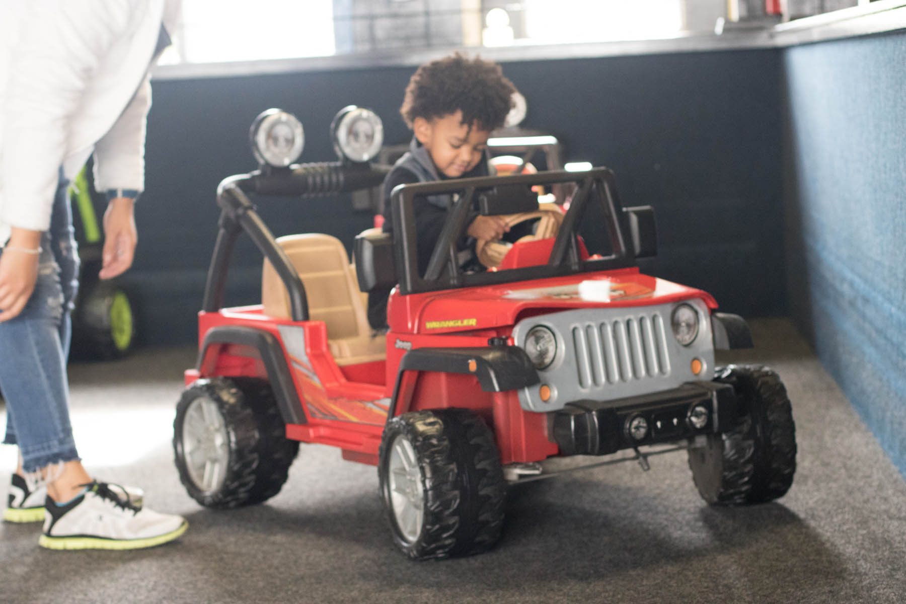 Young boy in toy jeep.