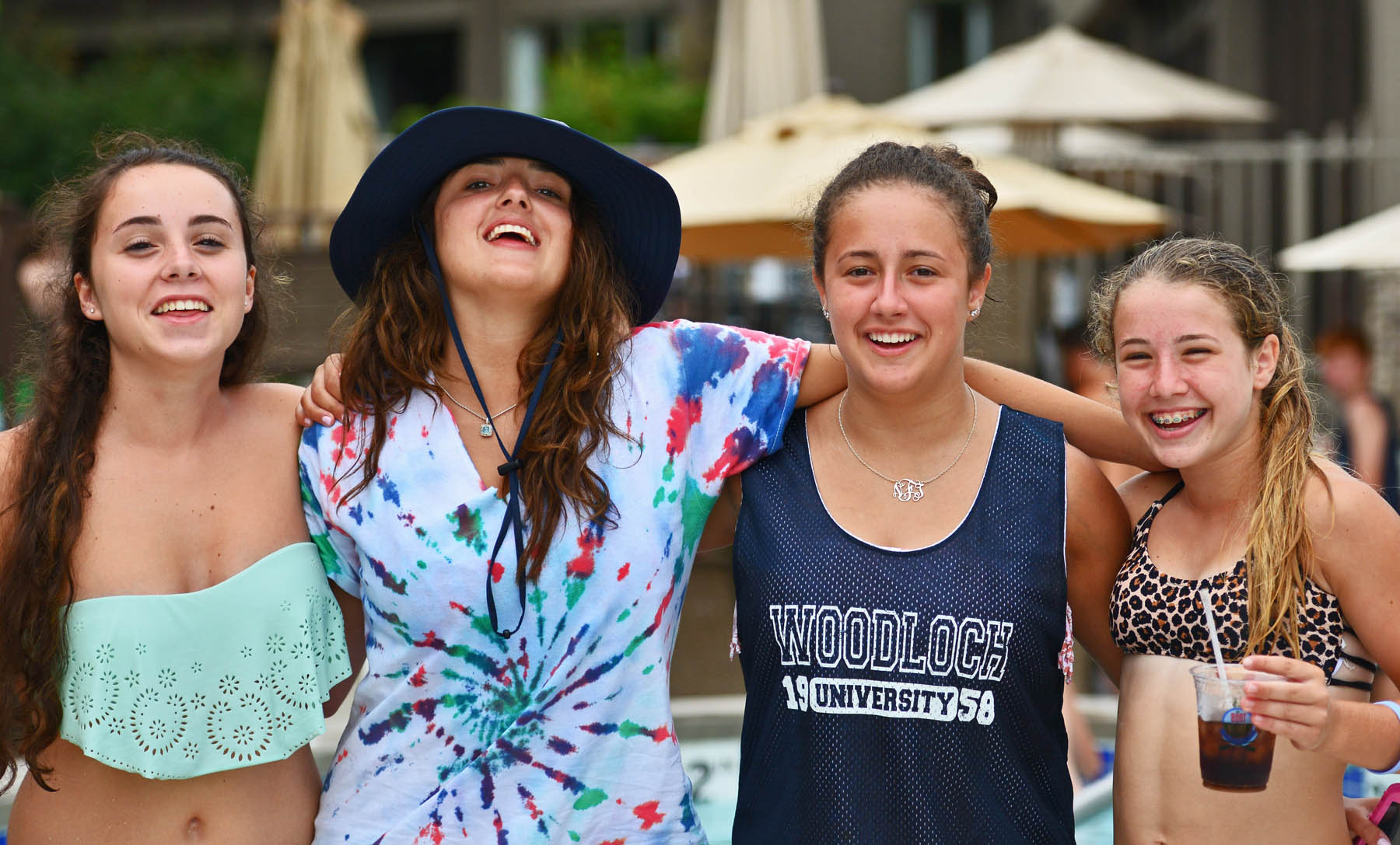 Young women posing together at outdoor pool.