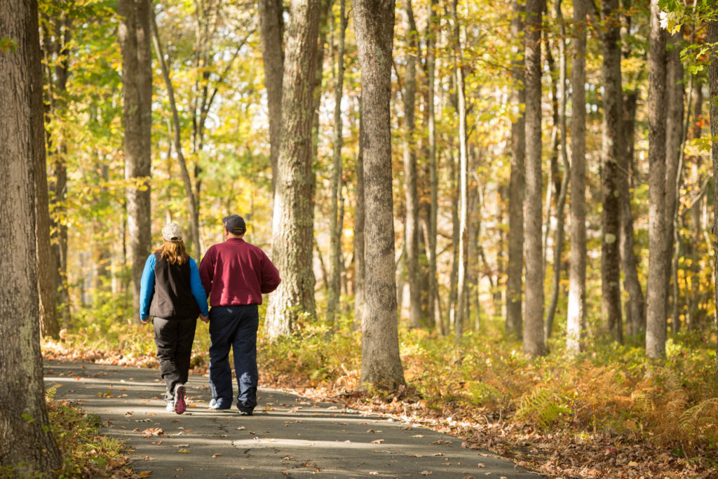 Man and woman on nature trail walk in autumn.