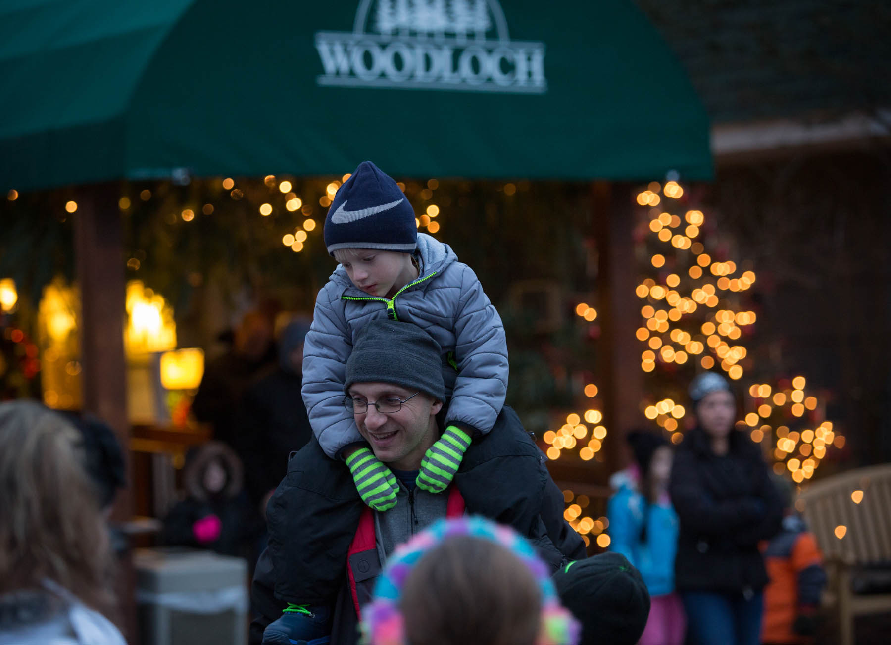 Father and son on shoulders with winter jackets and hats.