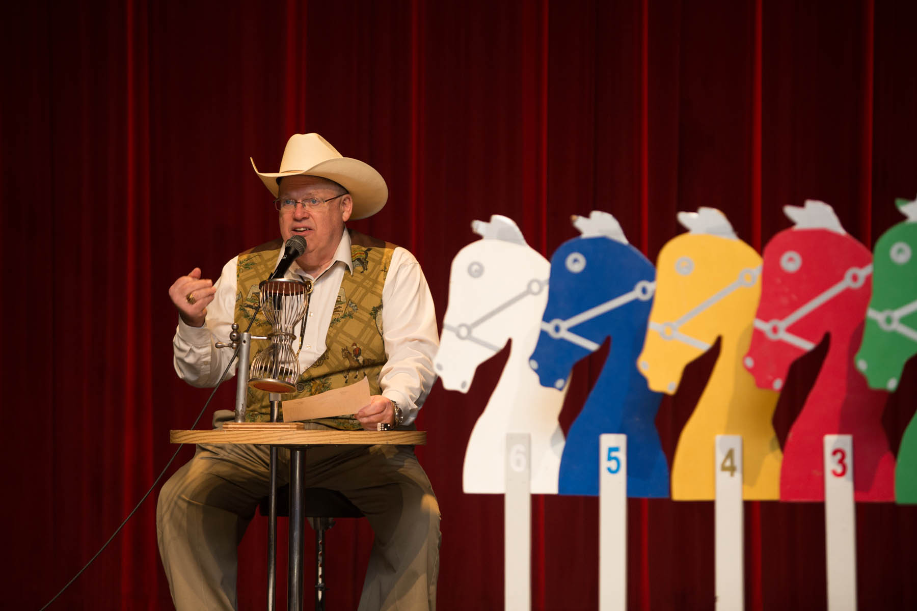 Horse race announcer on stage.