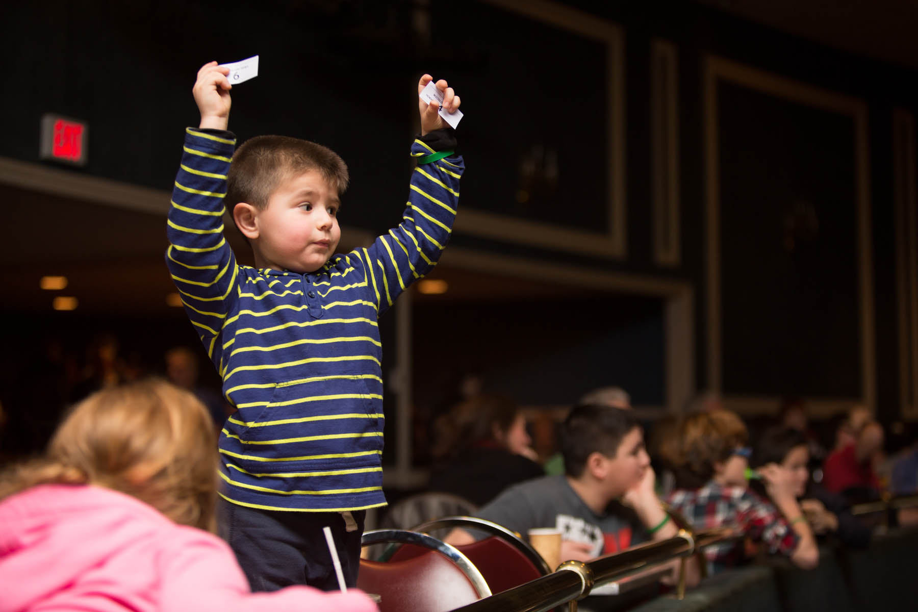 Young boy standing in the audience.