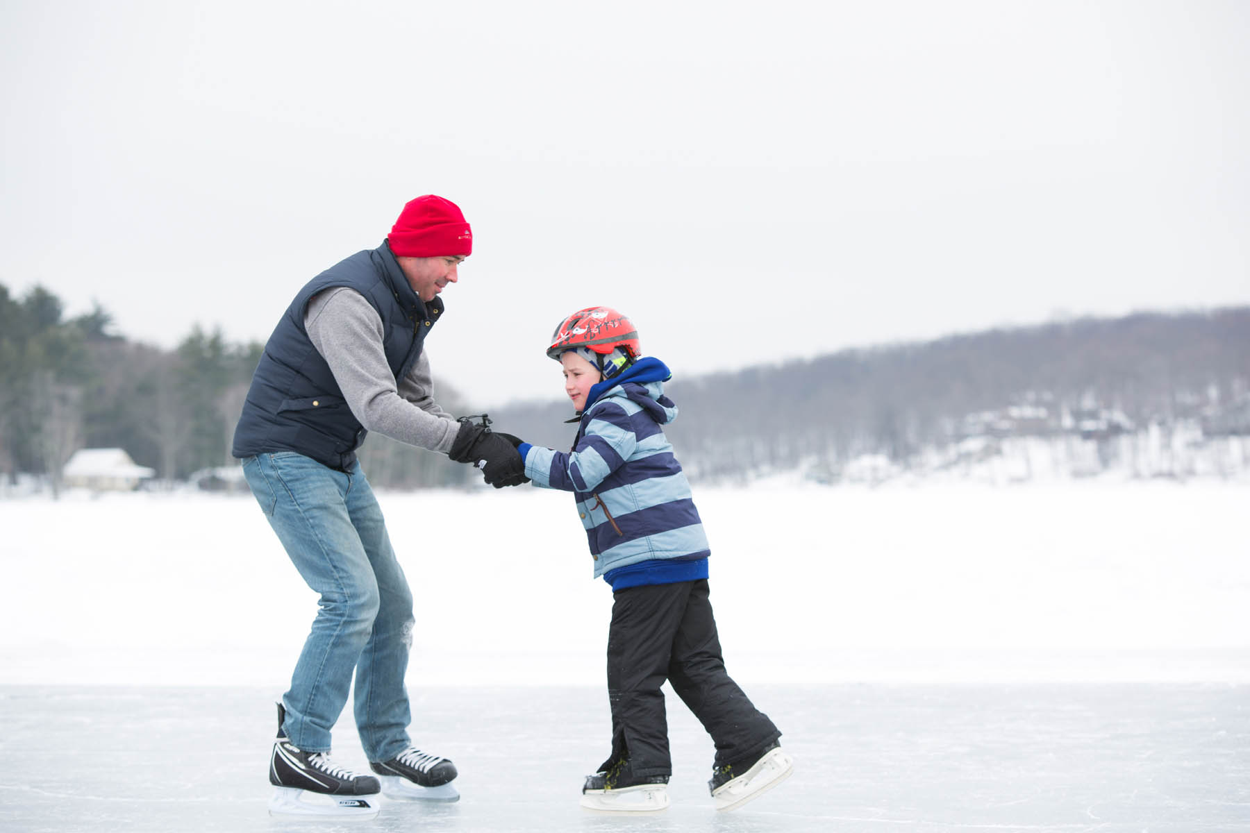 Father and son skating together outdoors.