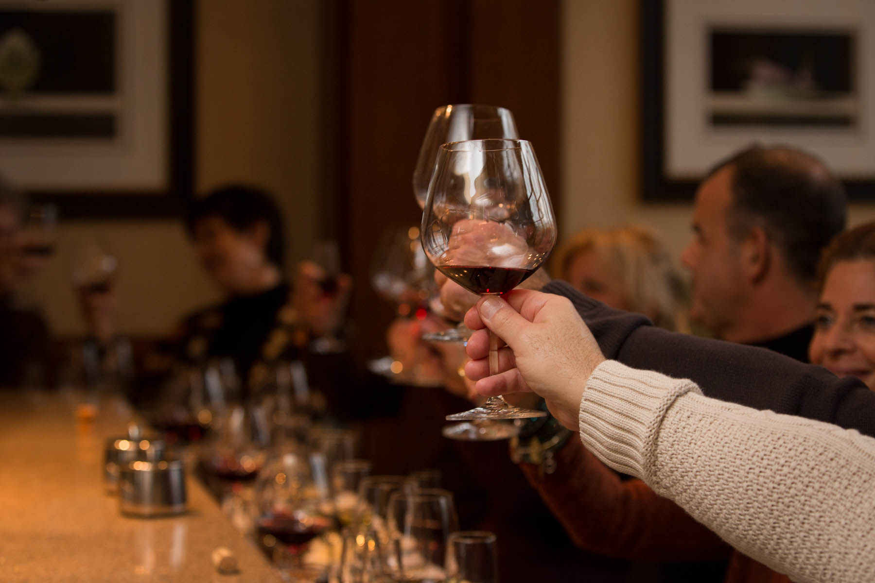 Close up of two people clinking glasses of liquor.