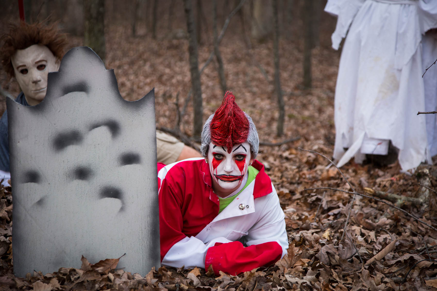 Scary clown and Micheal Meyers behind a gravestone.