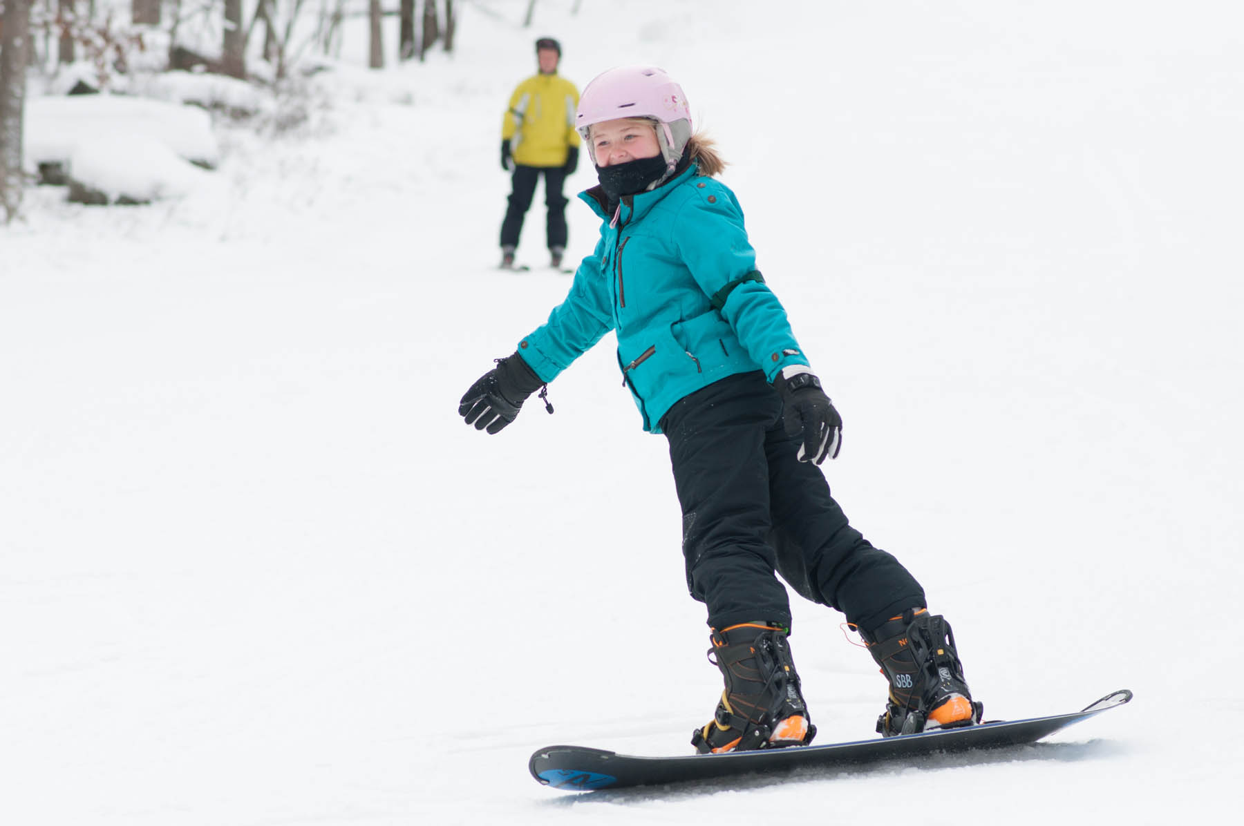 Snowboarder doing a toe slide downhill.