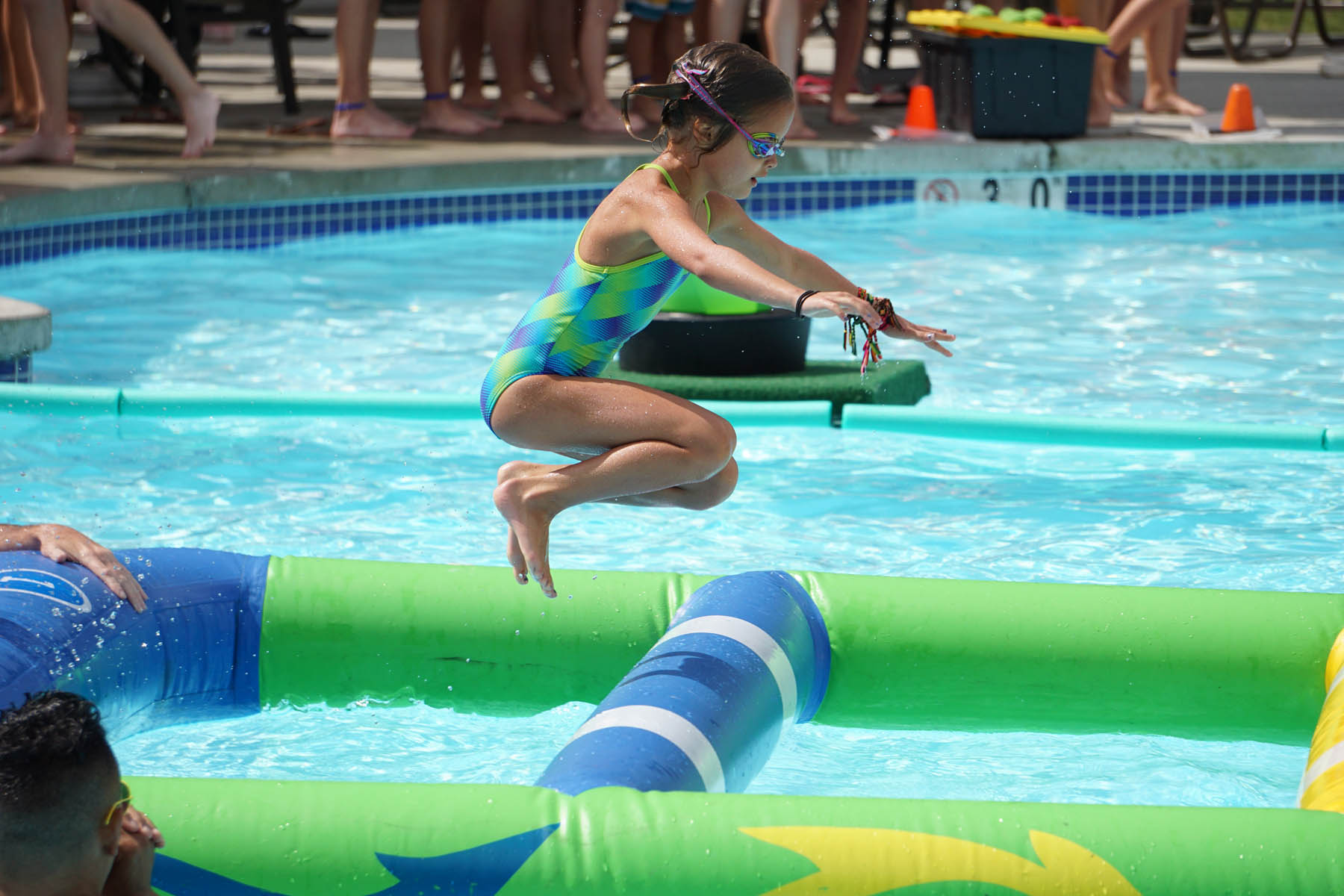Girl jumping in the pool.