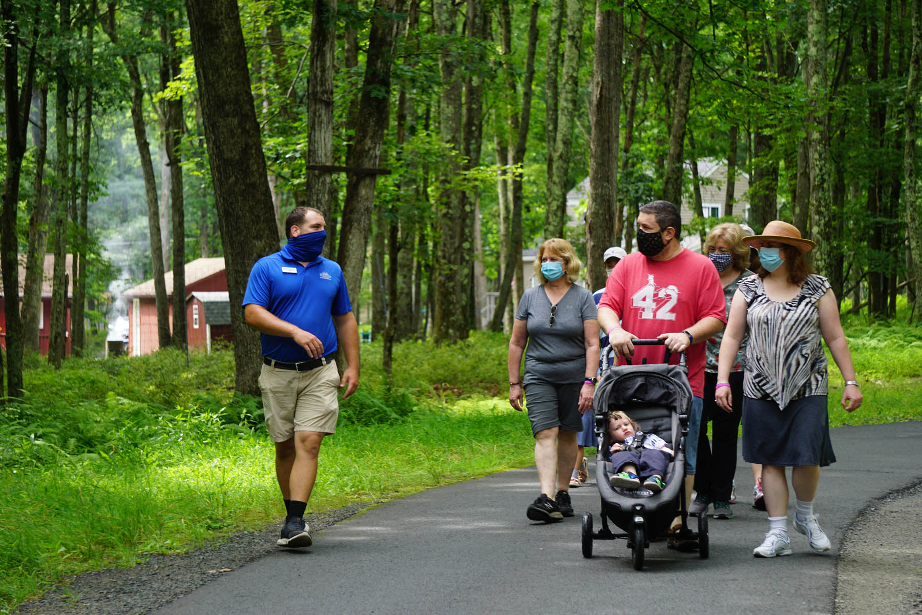 Masked guide and masked guests on nature trail walk.