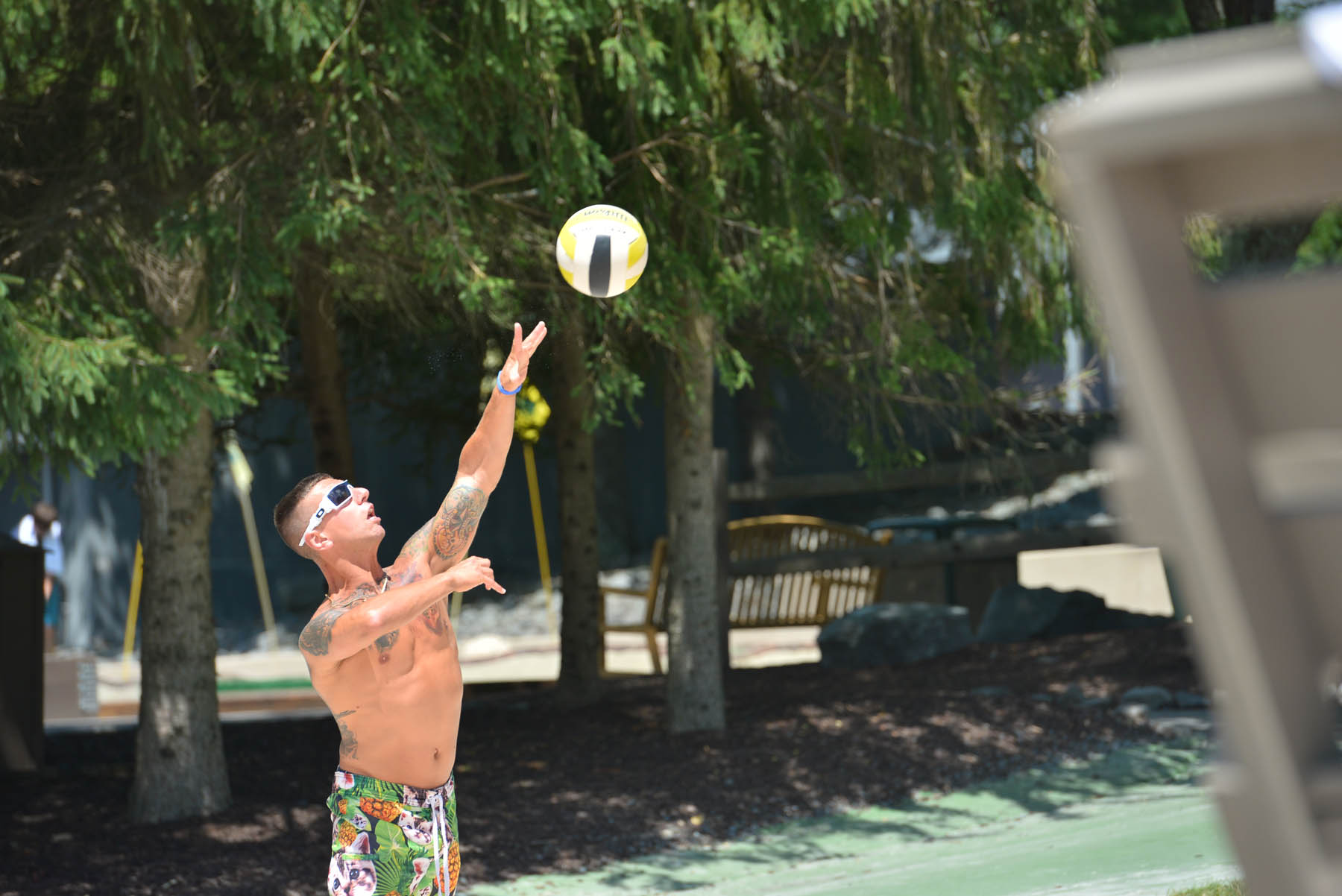 Man serving a volleyball outdoors.