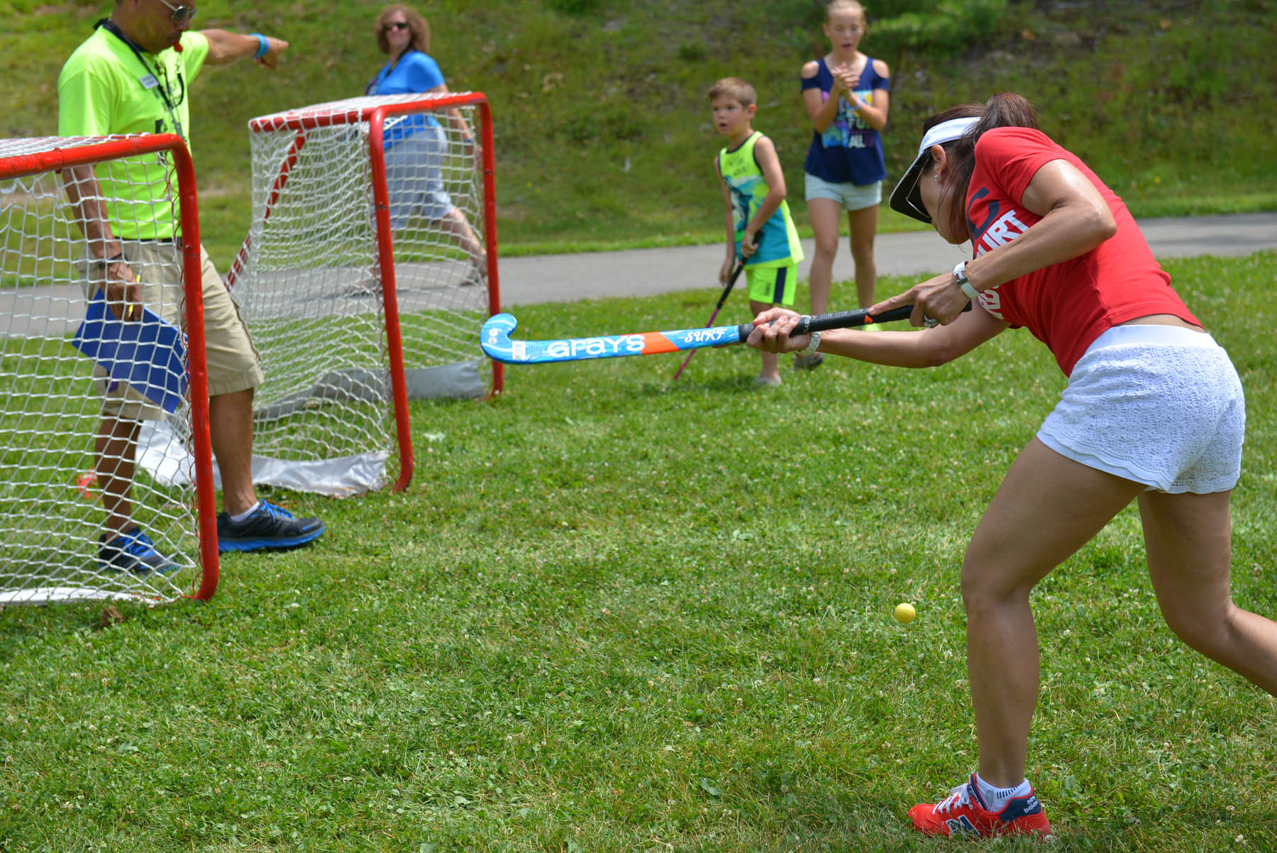 Young woman making a field hockey shot.