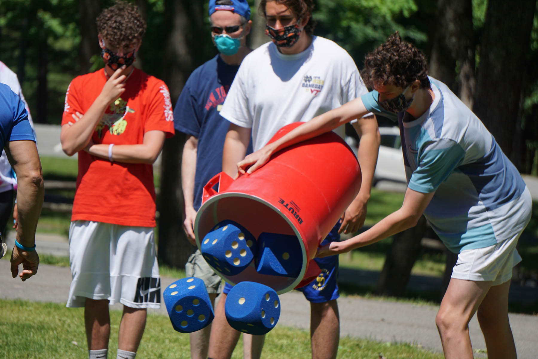 Person pouring giant dice out of a bucket.