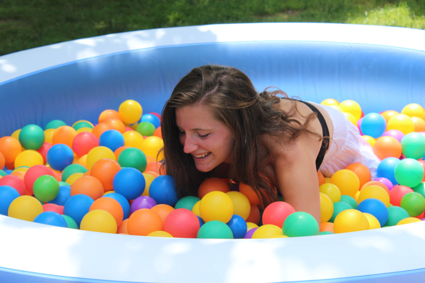 Woman digging through ball pit.