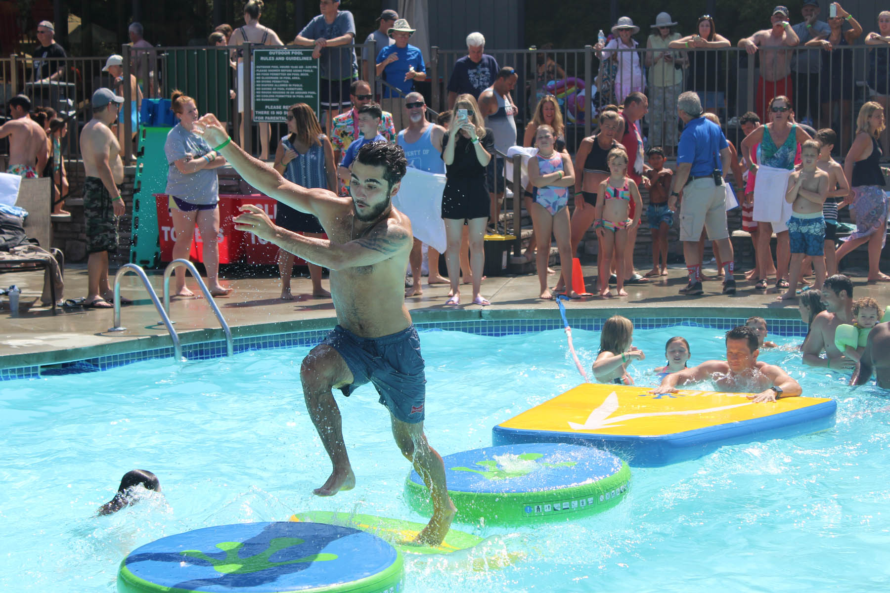 Man running across outdoor pool lilypads.