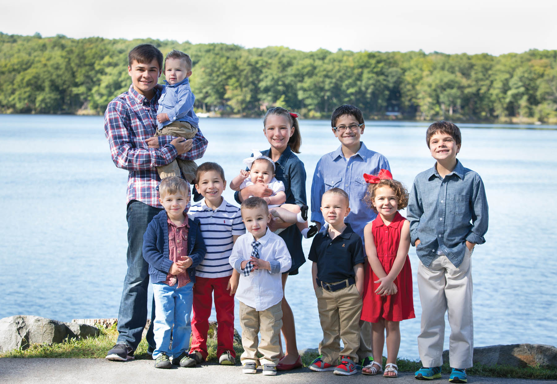 Children posing in nice clothes on the lake dock.