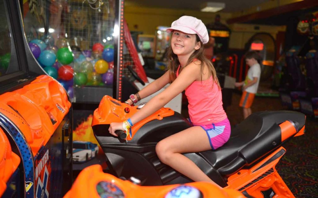 Young woman on an arcade motorcycle.