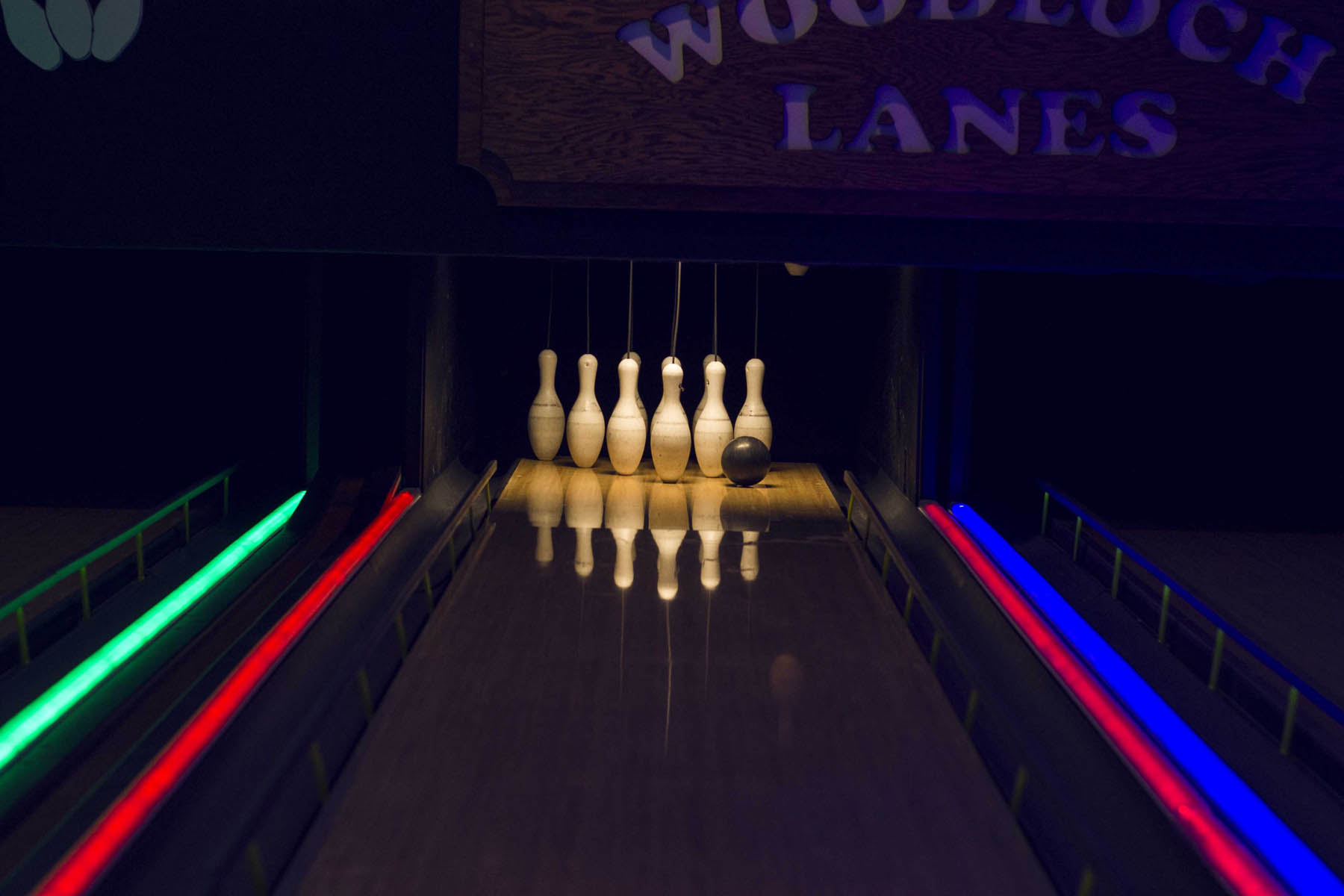 Bowling lane and ball with neon lane borders.