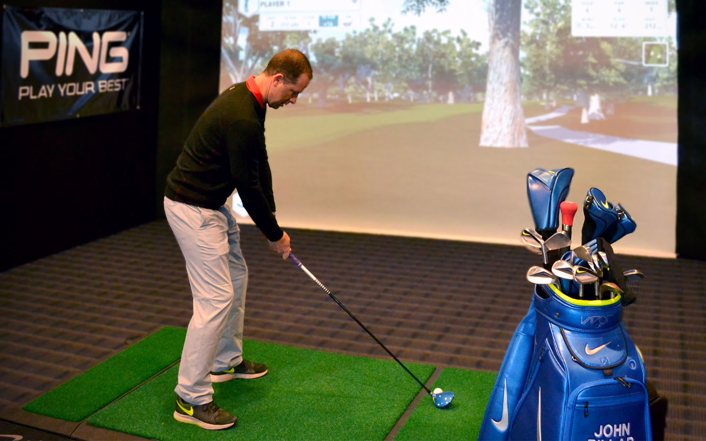Golfer preparing to swing in performance studio.