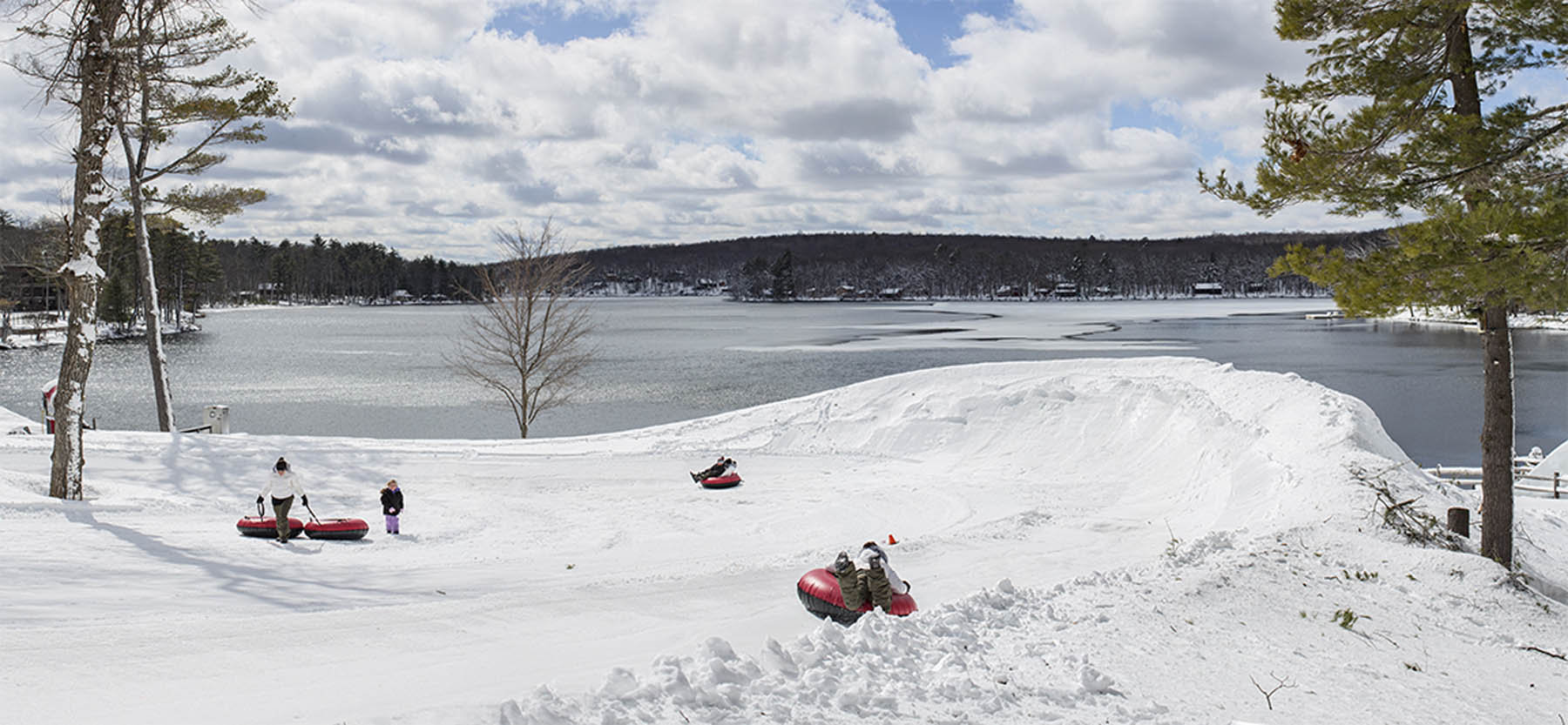 Guests tubing downhill in winter.