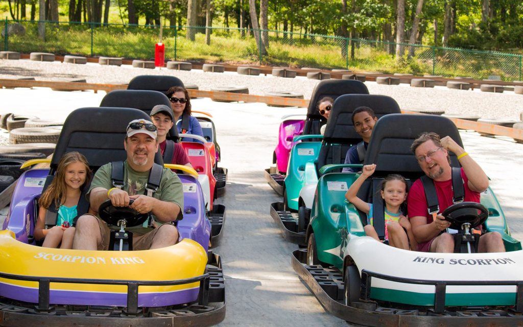 Group of adults and kids in go karts.