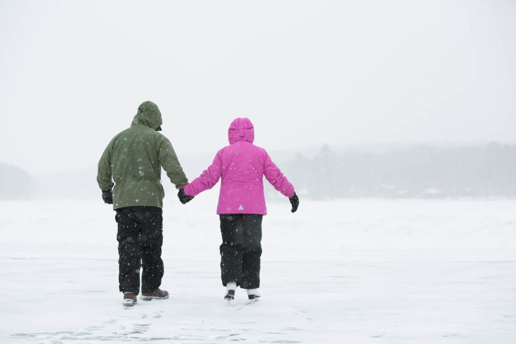 Two people walking on Lake Teedyuskung in winter.