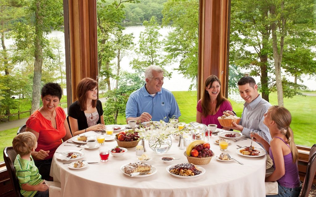 Family eating dinner and smiling.