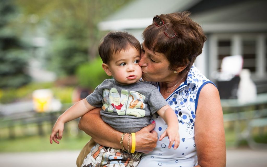 Grandmother kissing grandchild.