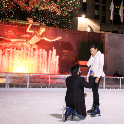 Man proposing to woman at the Rockafeller Center ice rink.