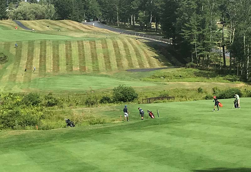 Junior golfers on golf course.
