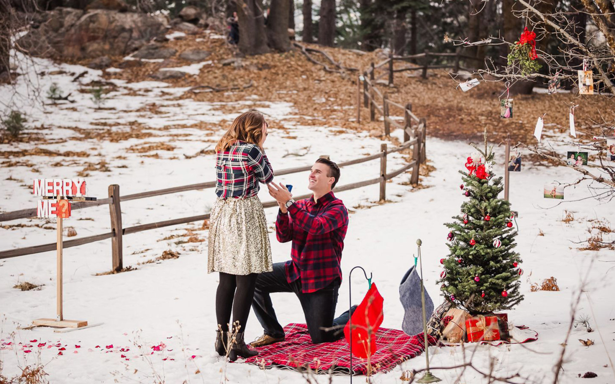 Man proposing to woman at holiday picnic.