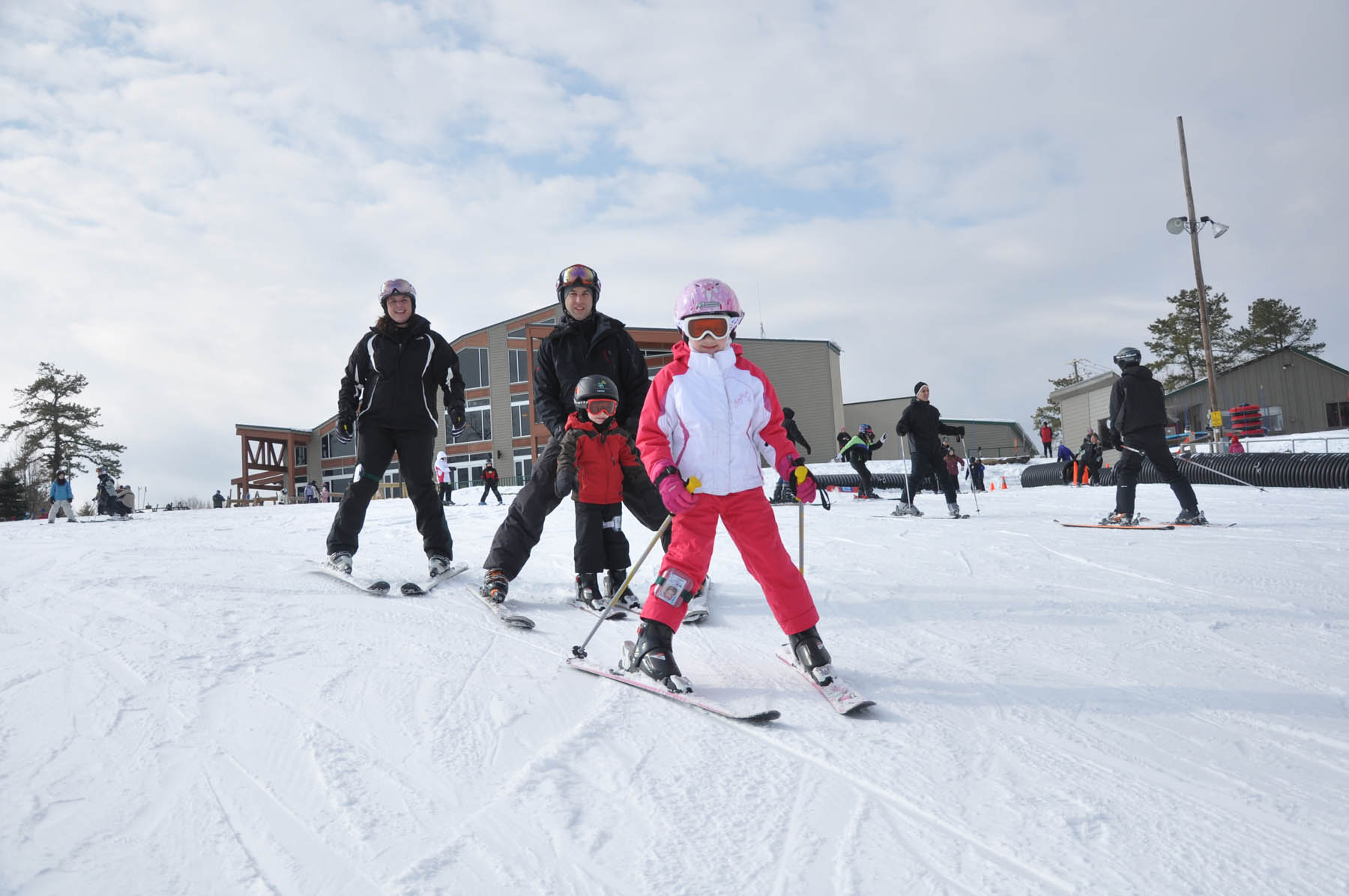 Parents and young children on skis.