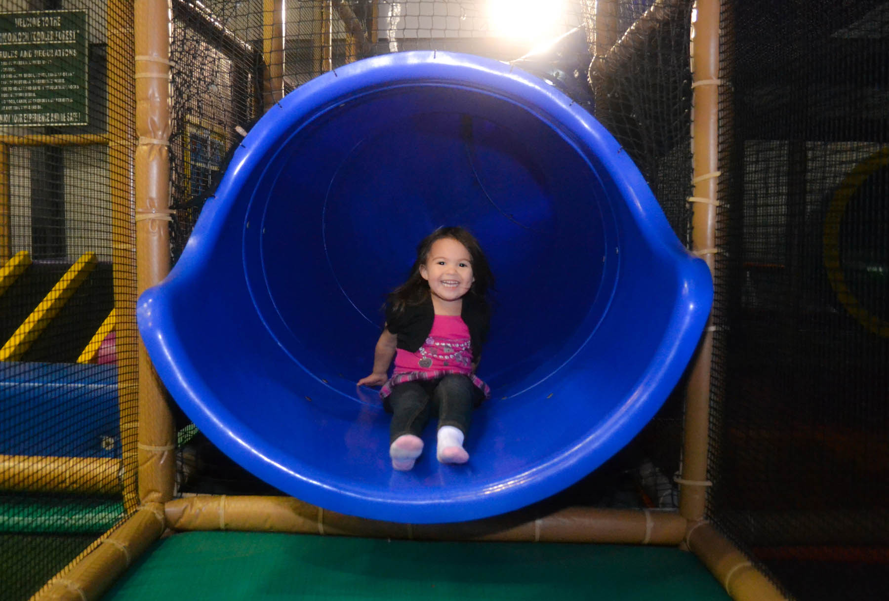Young girl at the bottom of a slide.