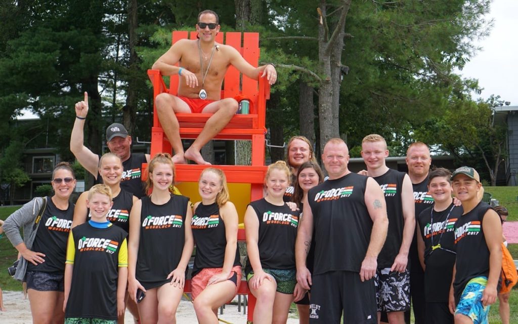 Group with matching t-shirts standing next to lifeguard.