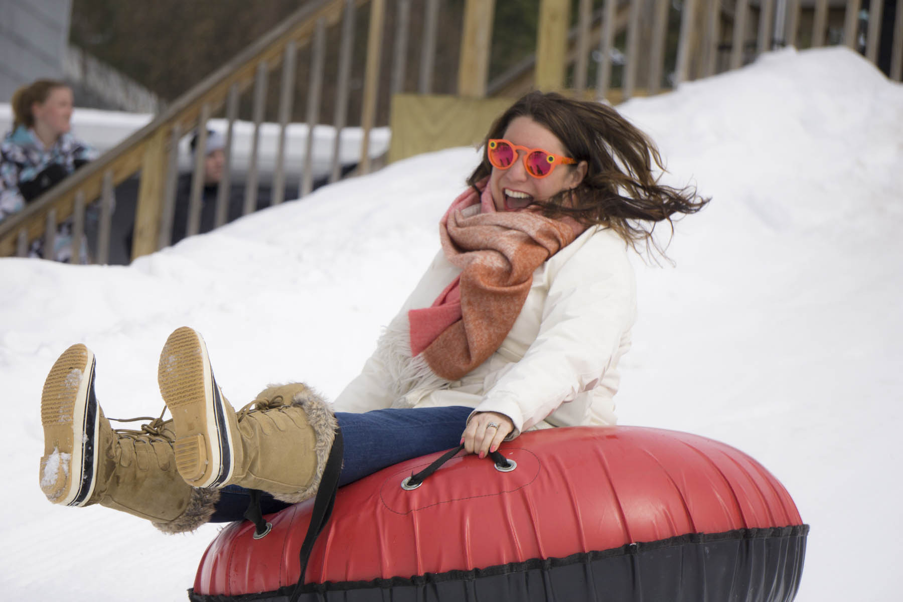 Woman sitting on snow tube.