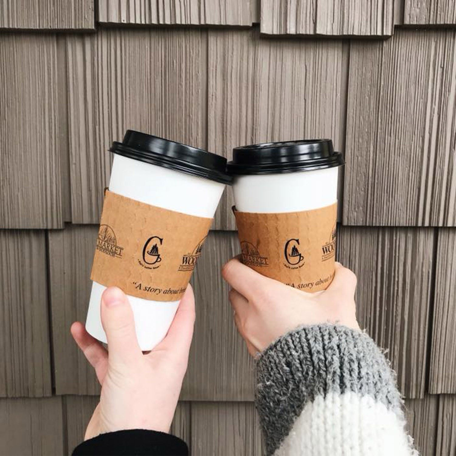 Hands clinking to-go coffee cups